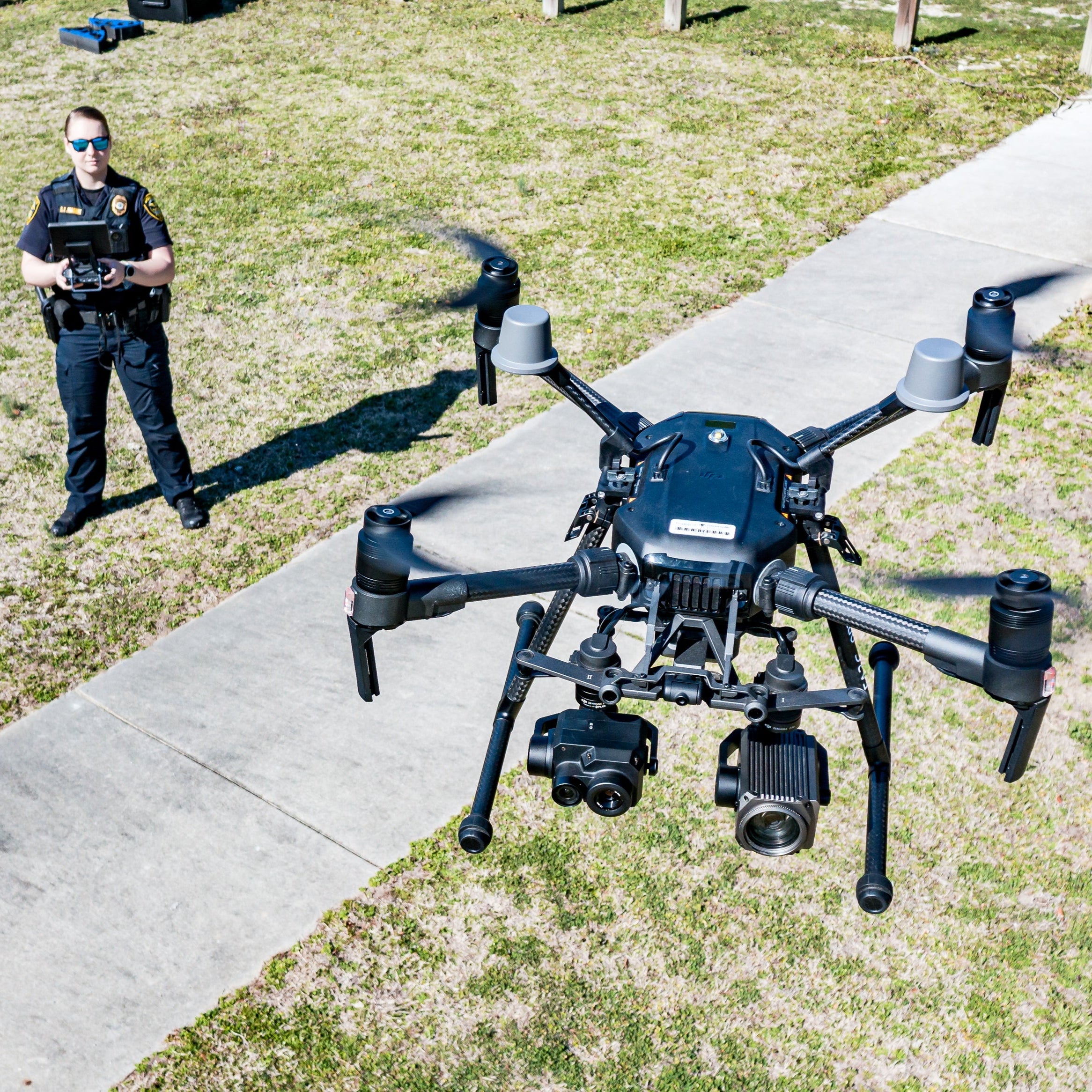 black uav drone closeup with pilot in background
