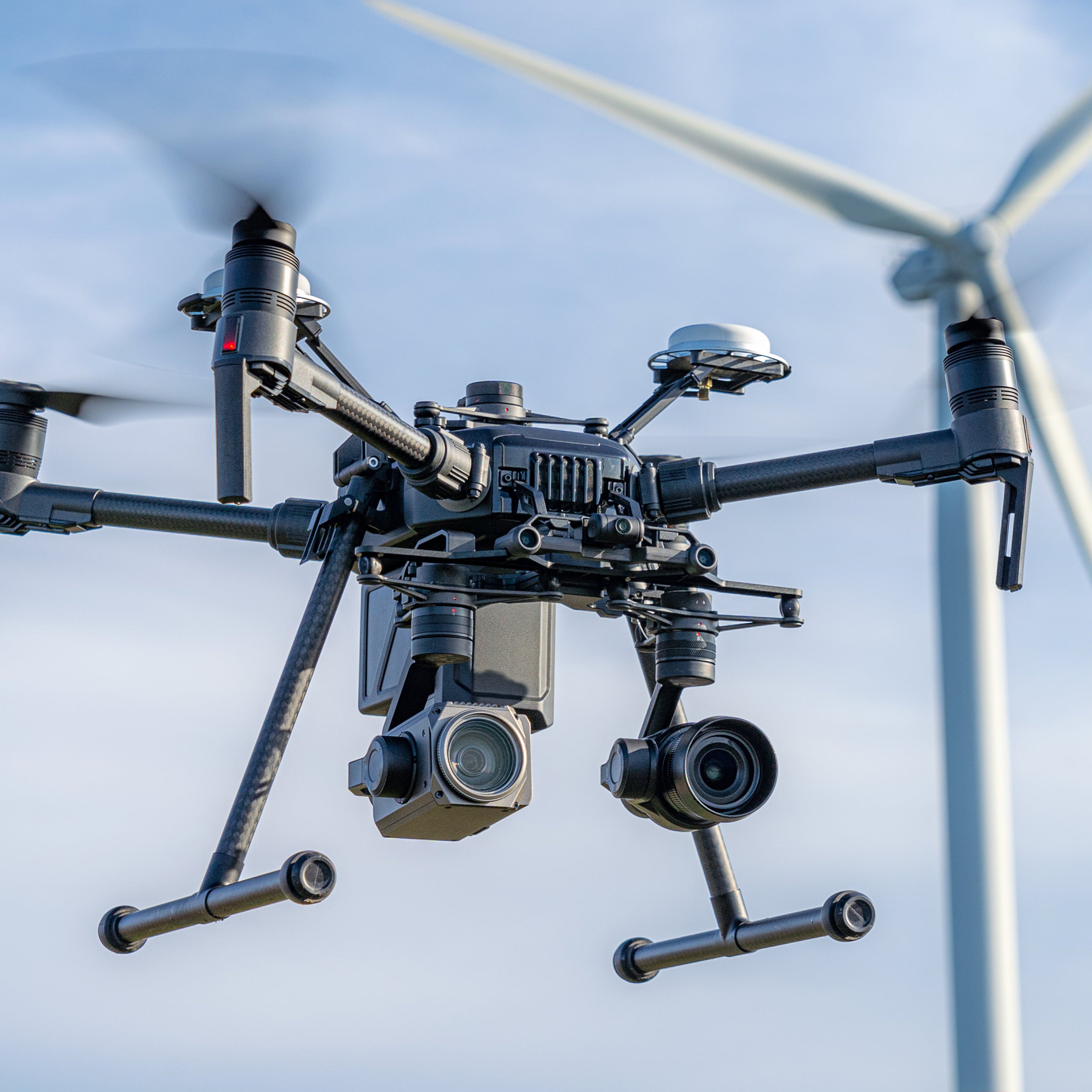 closeup of a UAV with a wind turbinel in the background
