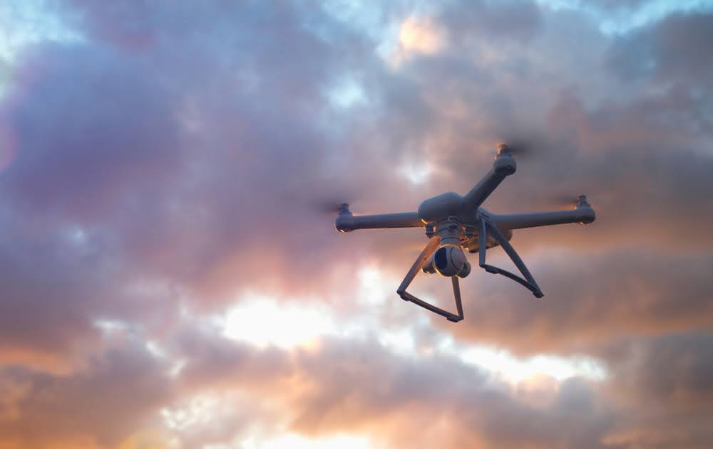 uav drone aerial shot from below with a cloud filled sunset sky in the background